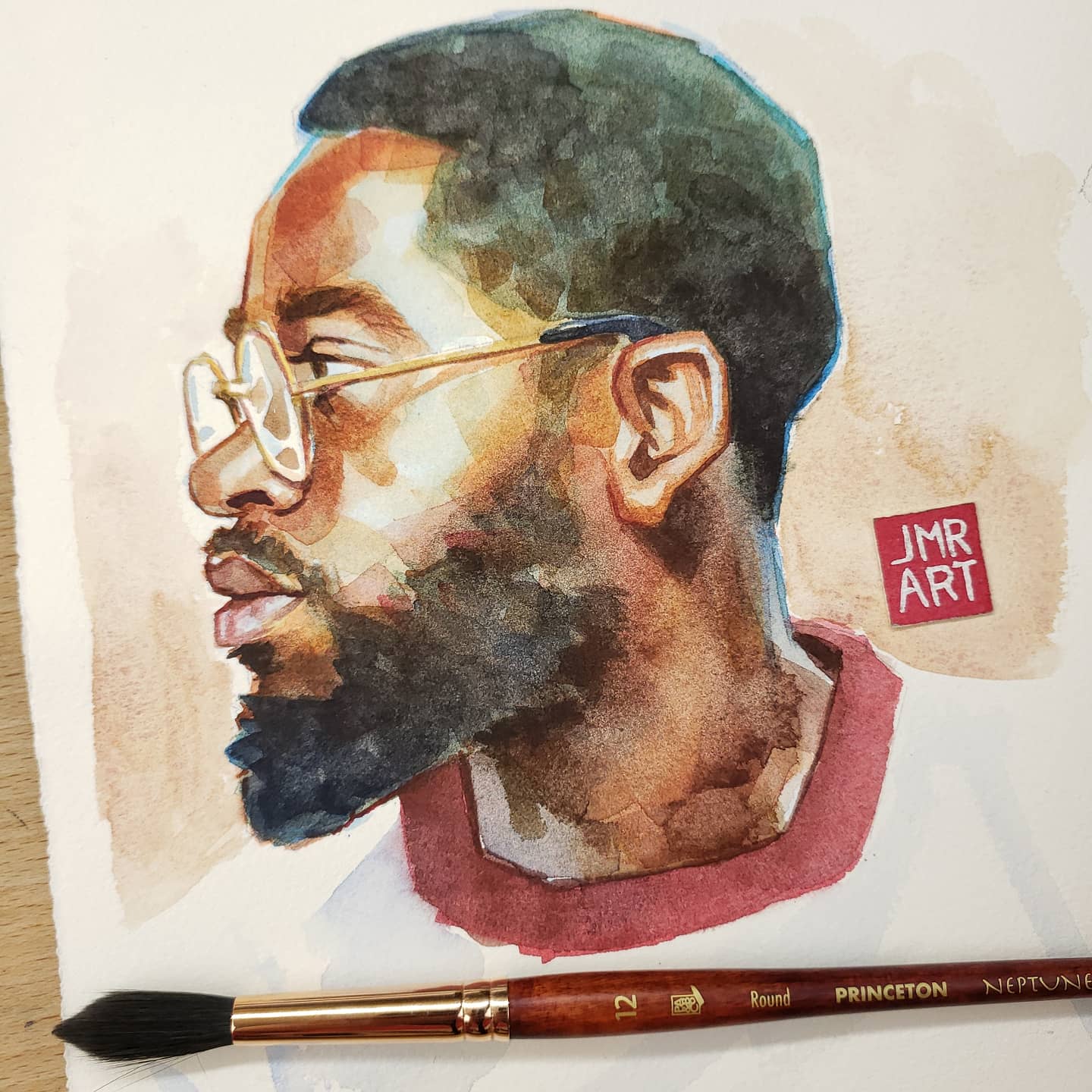 "Watercolor portrait of a man with glasses and a beard, featuring brush details."